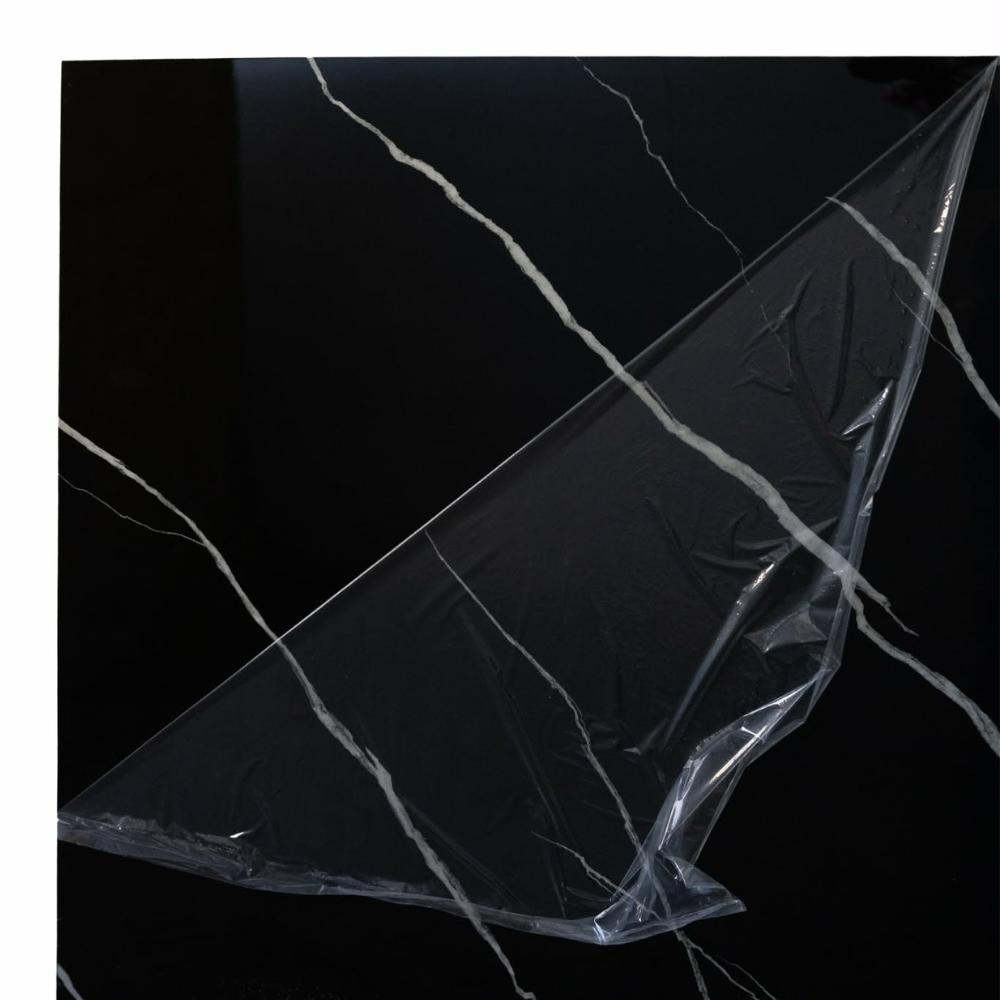 Realne zdjęcie panelu PCV czarny marmur, zbliżenie na błyszczącą powierzchnię i białe żyłki.